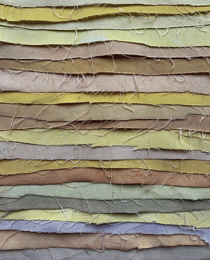 Swatches of fabric that have been dyed red, yellow, green, and purple using natural dyes