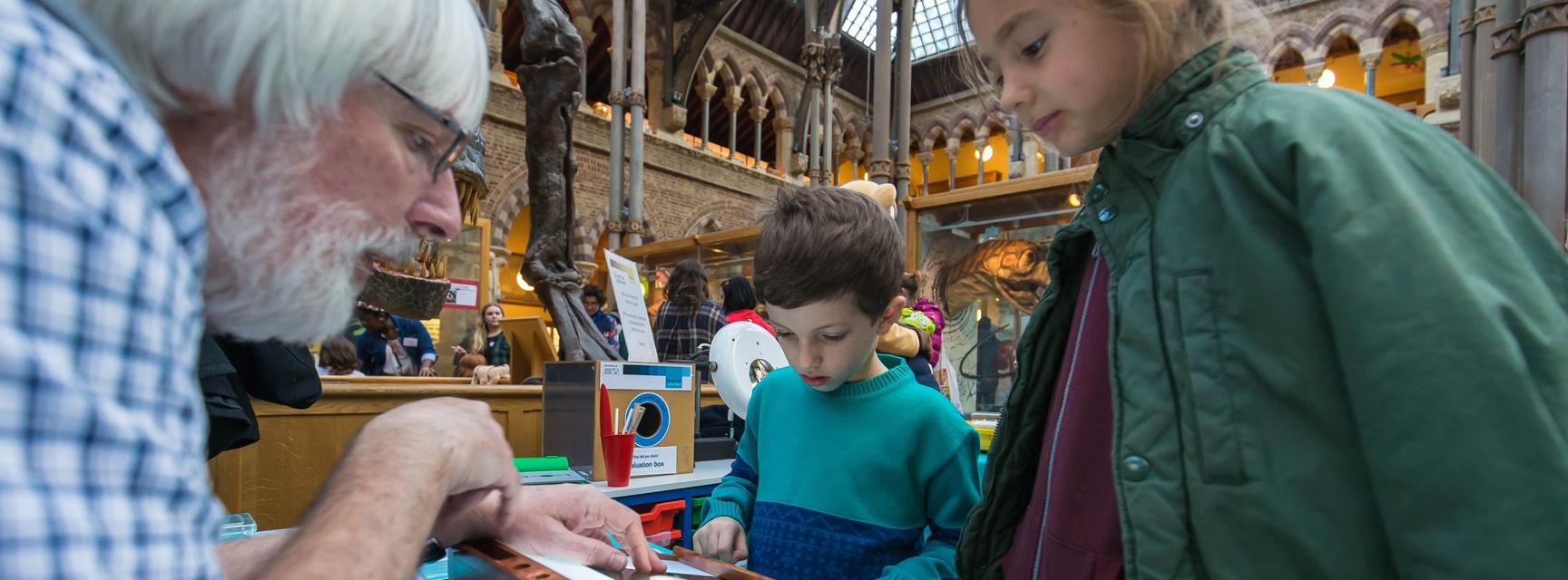 Two children chatting to a scientist at Science Saturdays