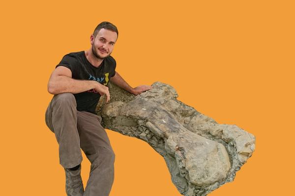 Dean Lomax with a partially-excavated dinosaur limb bone