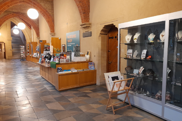The Museum shop with gifts on counters and a till. There is also a cabinet of jewellery..