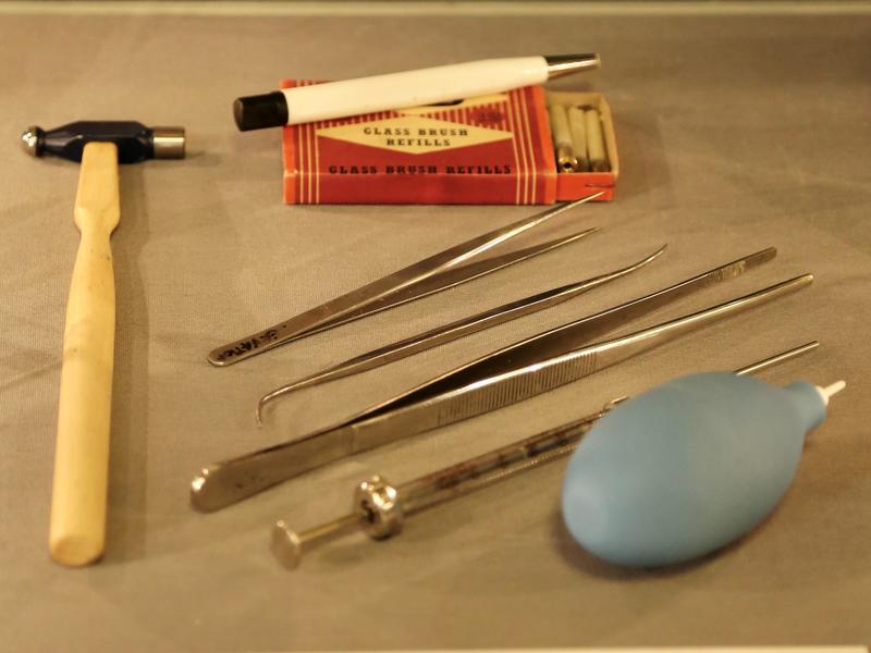 A scalpel, modelling tools, forceps, dissecting tools, and an air puffer