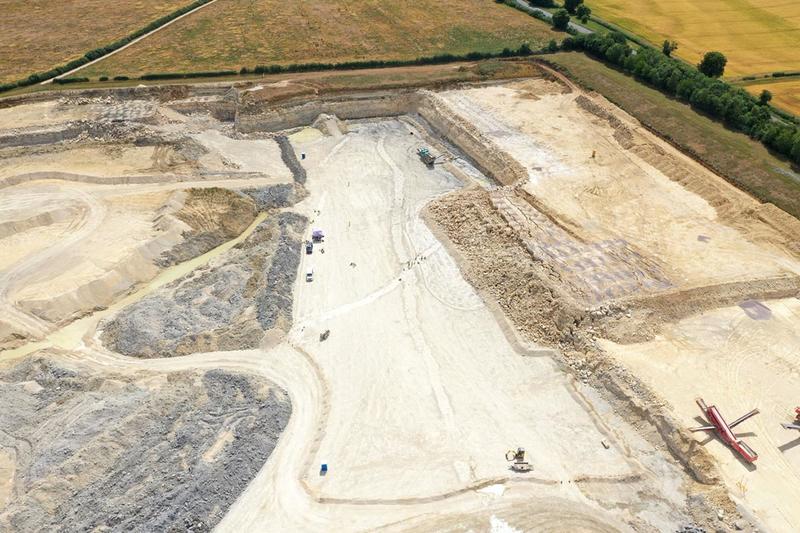 Aerial view of the Dewars Farm excavation site showing quarry layers, vehicles, and ongoing dinosaur trackway excavation work. Aerial view of the Dewars Farm excavation site showing quarry layers, vehicles, and ongoing dinosaur trackway excavation work.
