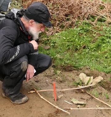 Tracker Bob Cowley looking at some tracks in the mud